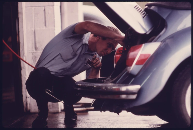 Homem arrumando motor fusca azul (soco)